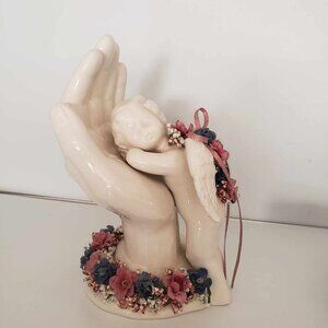 Vintage cherub resting on Jesus' hand